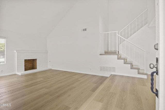 196 Mariposa Dr, Camarillo, CA 93012 - unfurnished living room featuring high vaulted ceiling, stairs, light wood finished floors, baseboards, and a fireplace
