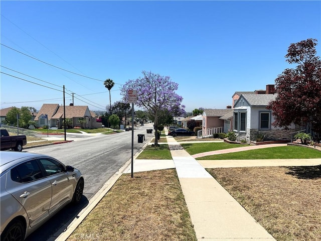 1923 W 115th St, Los Angeles, CA 90047 - view of asphalt road with a residential view, sidewalks, and curbs