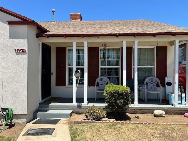 1923 W 115th St, Los Angeles, CA 90047 - property entrance featuring a porch, a chimney, stucco siding, and a shingled roof