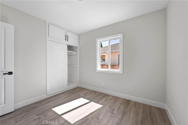 1715 E Redwood Ave, Anaheim, CA 92805 - unfurnished bedroom featuring light wood-style flooring, a closet, and baseboards