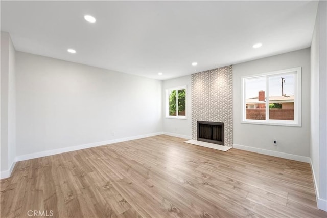 1715 E Redwood Ave, Anaheim, CA 92805 - unfurnished living room with a tiled fireplace, baseboards, light wood-style flooring, and recessed lighting