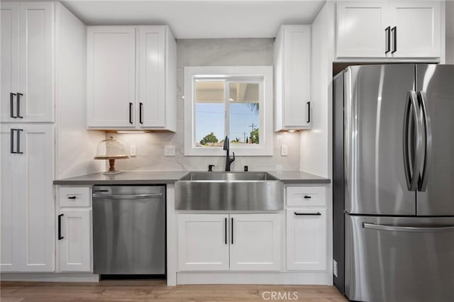 1715 E Redwood Ave, Anaheim, CA 92805 - kitchen featuring appliances with stainless steel finishes, a sink, white cabinetry, and light wood-style flooring