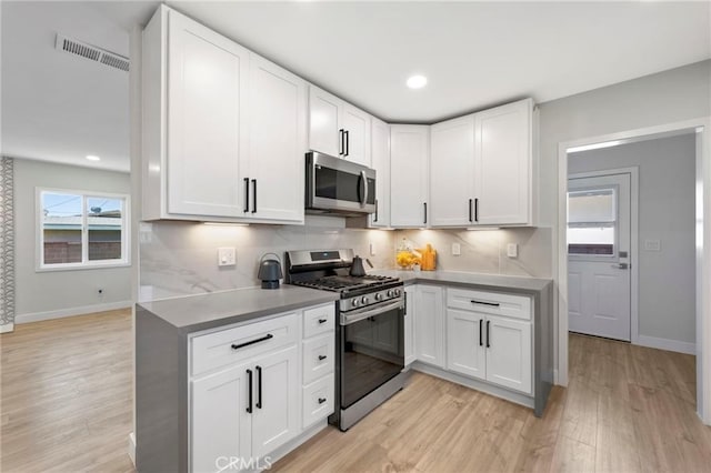 1715 E Redwood Ave, Anaheim, CA 92805 - kitchen featuring stainless steel appliances, baseboards, white cabinets, light wood-style floors, and recessed lighting