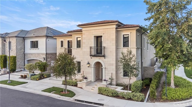 51 Eider Run, Irvine, CA 92618 - view of front of house featuring a balcony, stone siding, and stucco siding