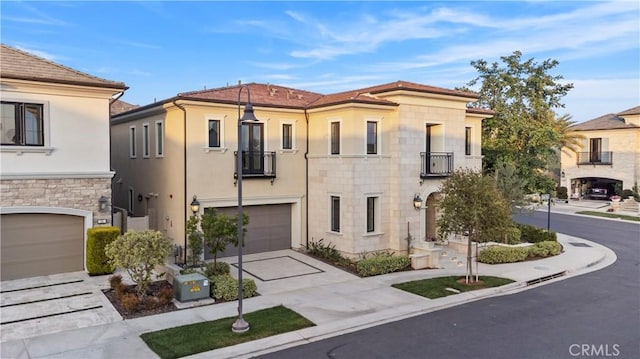 51 Eider Run, Irvine, CA 92618 - mediterranean / spanish-style home with a balcony, driveway, a garage, stucco siding, and stone siding