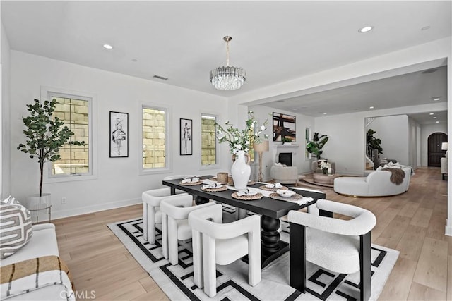 51 Eider Run, Irvine, CA 92618 - dining space with a fireplace, light wood-style flooring, a chandelier, plenty of natural light, and recessed lighting