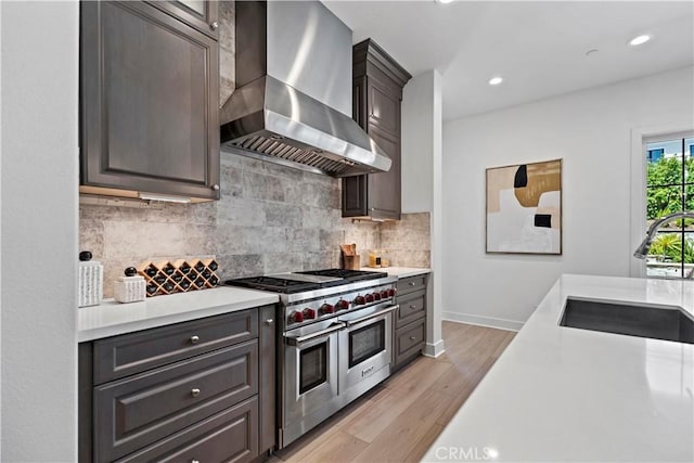 51 Eider Run, Irvine, CA 92618 - kitchen with wall chimney exhaust hood, double oven range, light countertops, tasteful backsplash, and recessed lighting