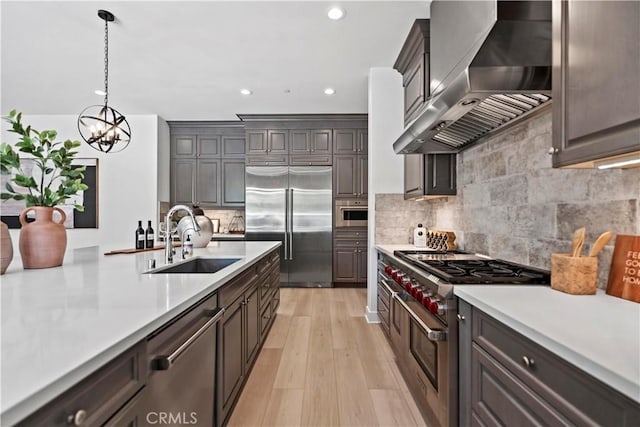 51 Eider Run, Irvine, CA 92618 - kitchen with wall chimney exhaust hood, high quality appliances, light countertops, a chandelier, and light wood-type flooring