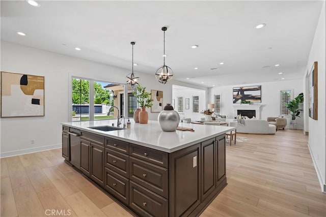 51 Eider Run, Irvine, CA 92618 - kitchen with dark brown cabinetry, light wood-style flooring, light countertops, recessed lighting, and an island with sink