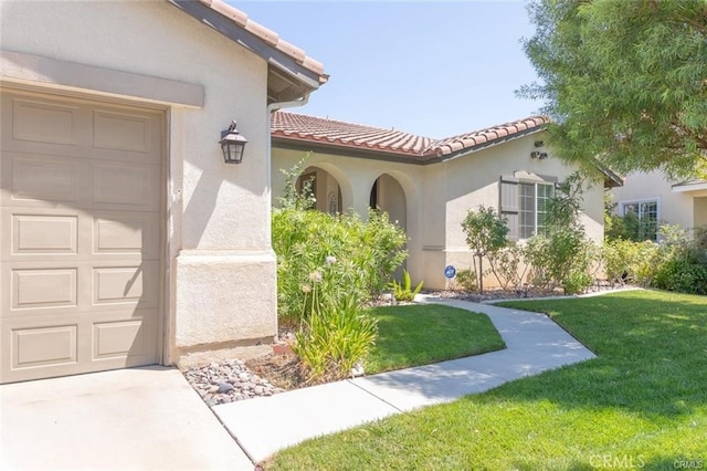 27840 Pointe Breeze Dr, Menifee, CA 92585 - doorway to property featuring a lawn, a tile roof, stucco siding, and a garage