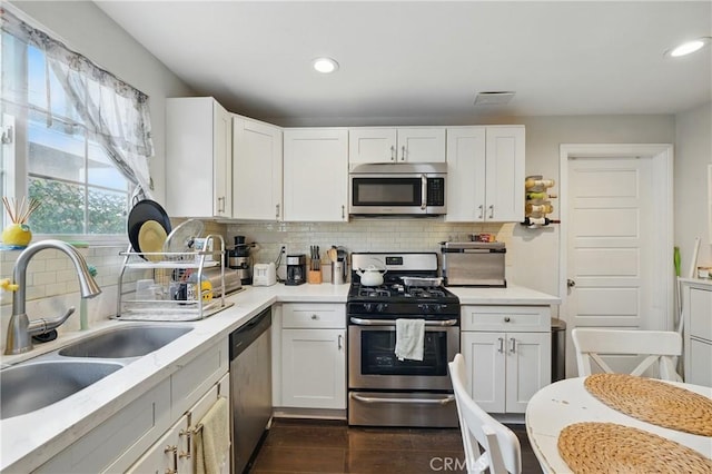 4819 Church St, Pico Rivera, CA 90660 - kitchen with appliances with stainless steel finishes, dark wood-style flooring, decorative backsplash, light countertops, and recessed lighting