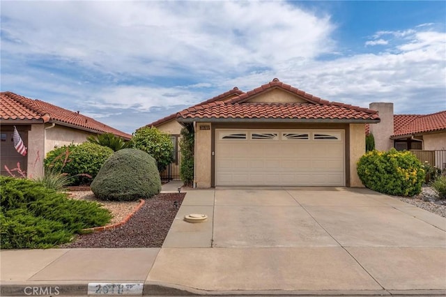 26181 Goldenwood St, Menifee, CA 92586 - mediterranean / spanish home featuring concrete driveway, a tiled roof, stucco siding, and an attached garage