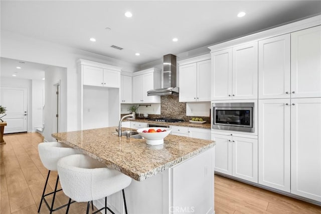 156 Barrow, Irvine, CA 92620 - kitchen featuring wall chimney exhaust hood, appliances with stainless steel finishes, a sink, decorative backsplash, and light stone countertops