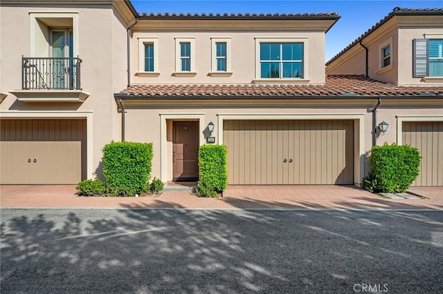 156 Barrow, Irvine, CA 92620 - townhome / multi-family property with a garage, a tiled roof, a balcony, stucco siding, and driveway