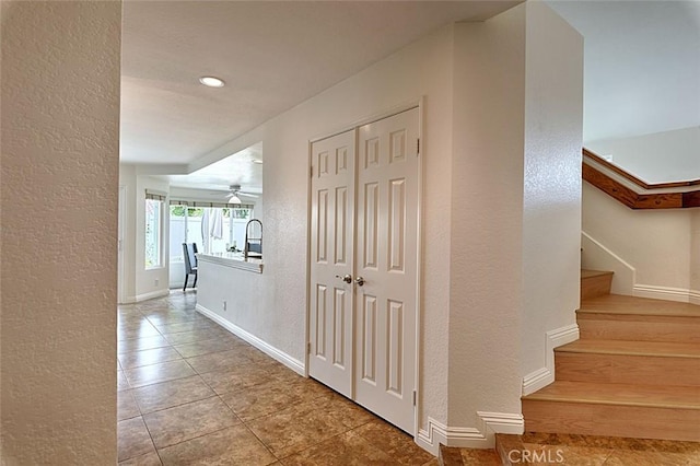 24650 Via Melinda, Yorba Linda, CA 92887 - hallway featuring a textured wall, tile patterned flooring, stairs, baseboards, and a sink
