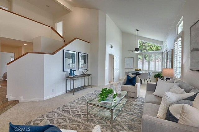 24650 Via Melinda, Yorba Linda, CA 92887 - carpeted living room with high vaulted ceiling, ceiling fan, baseboards, and stairway
