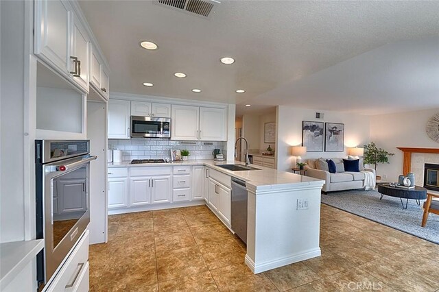 24650 Via Melinda, Yorba Linda, CA 92887 - kitchen featuring a sink, stainless steel appliances, a peninsula, white cabinetry, and open floor plan