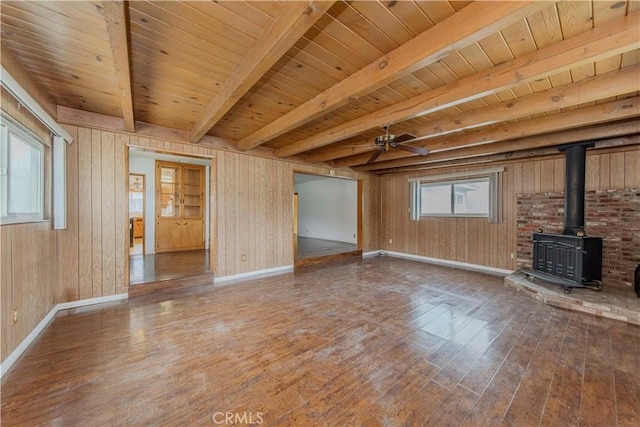 7236 Hellman Ave, Rancho Cucamonga, CA 91701 - unfurnished living room featuring wood finished floors, baseboards, a wood stove, wood walls, and wood ceiling with exposed beams