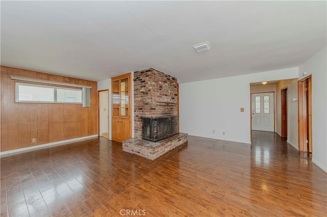 7236 Hellman Ave, Rancho Cucamonga, CA 91701 - unfurnished living room with wood finished floors, a brick fireplace, wooden walls, and baseboards