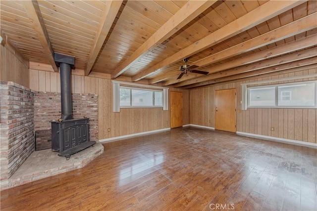 7236 Hellman Ave, Rancho Cucamonga, CA 91701 - unfurnished living room with hardwood / wood-style floors, baseboards, a wood stove, wood walls, and wood ceiling with exposed beams
