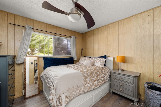 5015 Berryhill Pl, Riverside, CA 92507 - bedroom featuring wooden walls, dark wood-style flooring, a textured ceiling, and ceiling fan