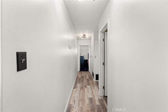 5015 Berryhill Pl, Riverside, CA 92507 - corridor with wood finished floors, baseboards, and a textured ceiling