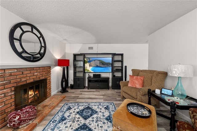 5015 Berryhill Pl, Riverside, CA 92507 - living area with wood finished floors, a textured ceiling, and a brick fireplace