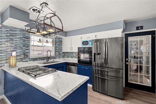 5015 Berryhill Pl, Riverside, CA 92507 - kitchen featuring appliances with stainless steel finishes, a sink, decorative backsplash, a peninsula, and white cabinets