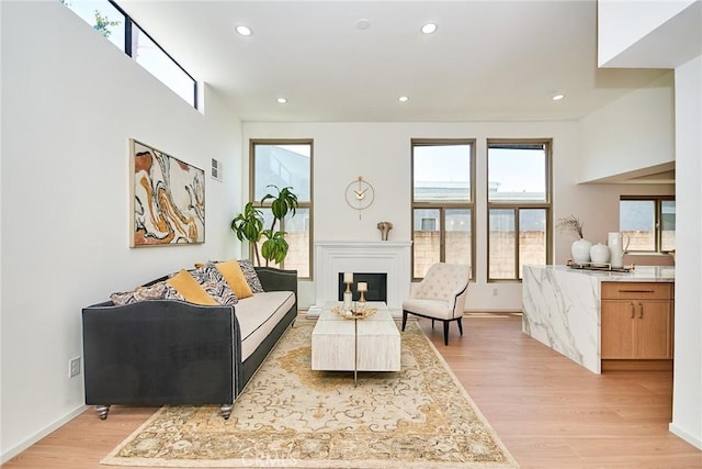 9539 Gladbeck Ave, Northridge, CA 91324 - living room featuring light wood finished floors, recessed lighting, a glass covered fireplace, and baseboards