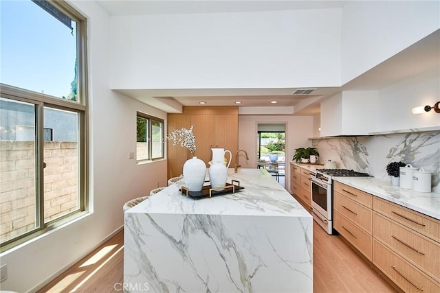 9539 Gladbeck Ave, Northridge, CA 91324 - kitchen with white range with gas cooktop, modern cabinets, light wood-style flooring, light brown cabinetry, and a towering ceiling