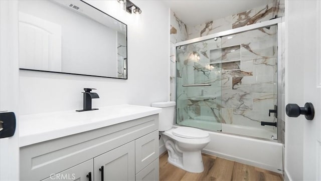 1208 Del Haven Ct, Redlands, CA 92374 - bathroom featuring vanity, wood finished floors, toilet, and bath / shower combo with glass door