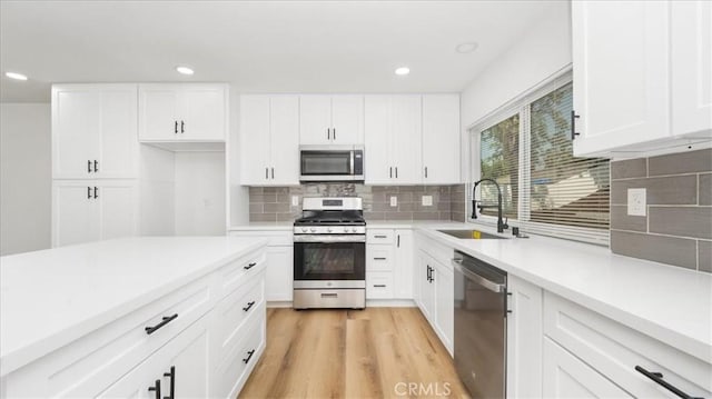 1208 Del Haven Ct, Redlands, CA 92374 - kitchen featuring stainless steel appliances, a sink, decorative backsplash, light countertops, and white cabinets