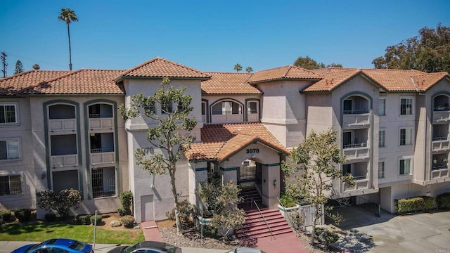 3078 Broadway Unit 107, San Diego, CA 92102 - mediterranean / spanish-style home with stucco siding, a tile roof, and stairway