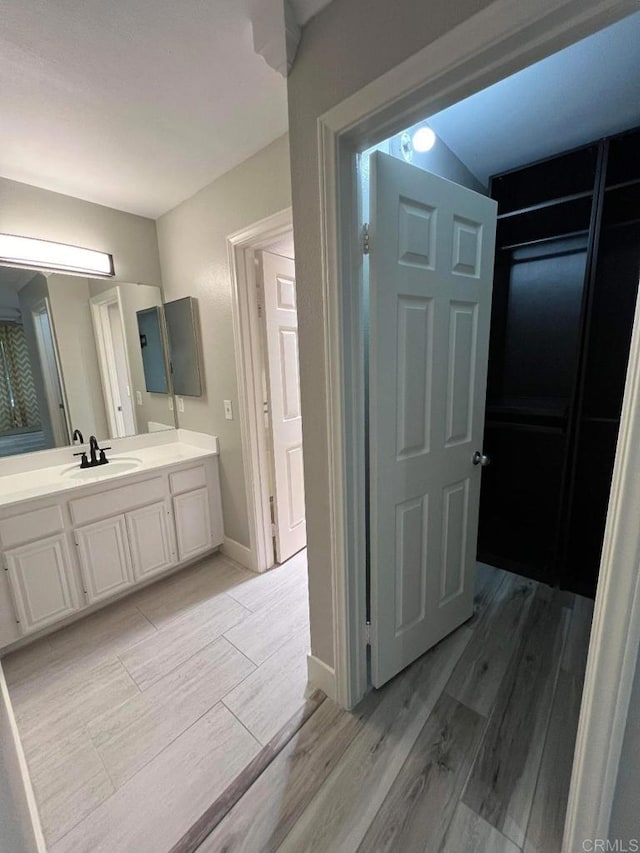 3078 Broadway Unit 107, San Diego, CA 92102 - bathroom with wood finished floors, vanity, and baseboards