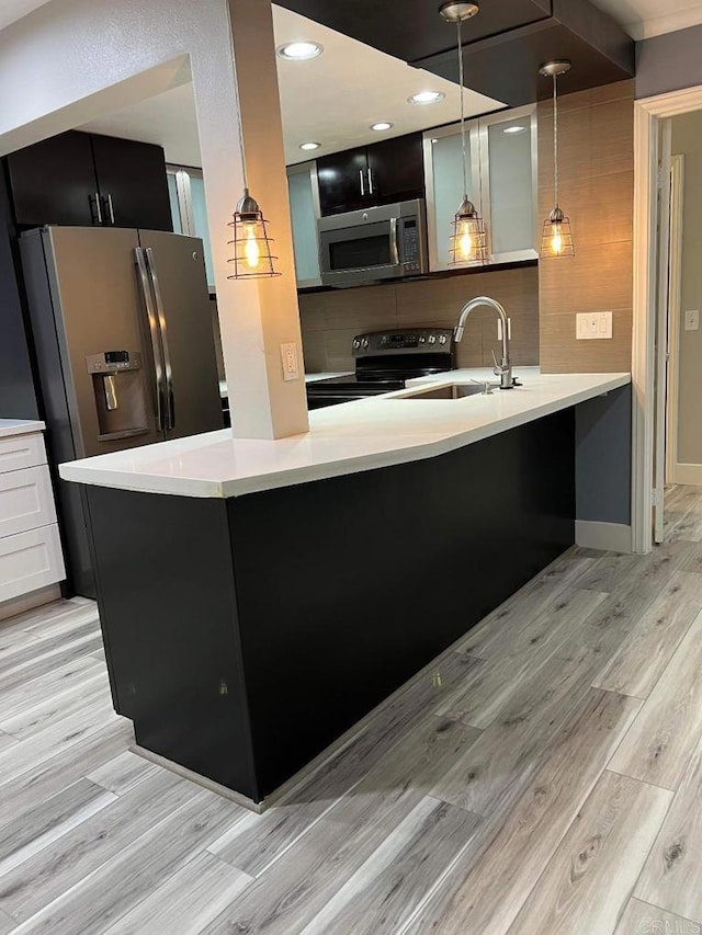3078 Broadway Unit 107, San Diego, CA 92102 - kitchen featuring appliances with stainless steel finishes, dark cabinets, a sink, and light wood finished floors