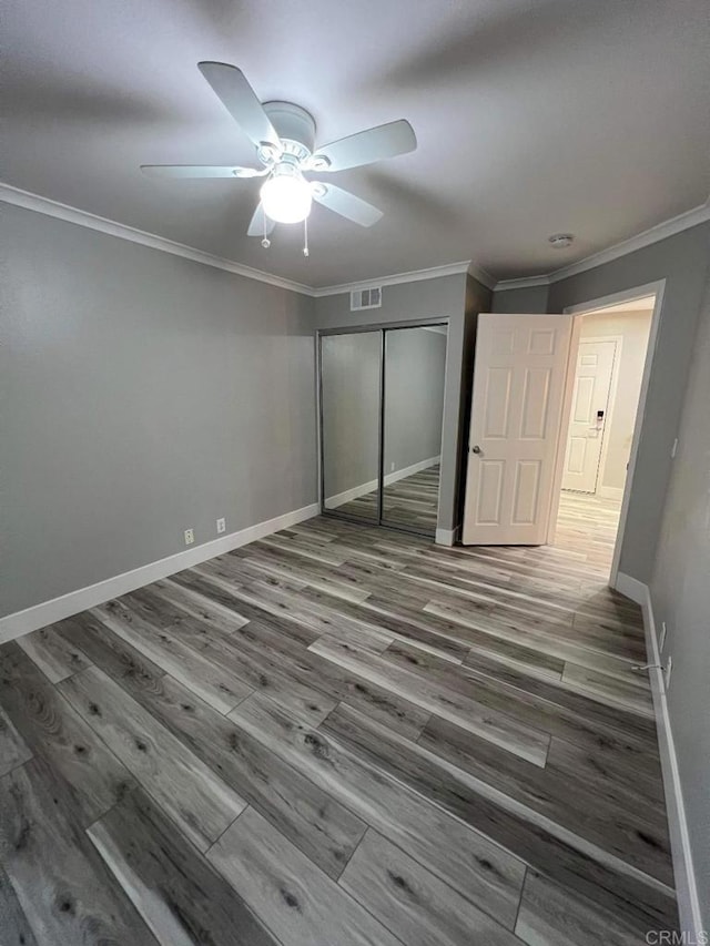 3078 Broadway Unit 107, San Diego, CA 92102 - unfurnished bedroom featuring a closet, baseboards, wood finished floors, ornamental molding, and ceiling fan