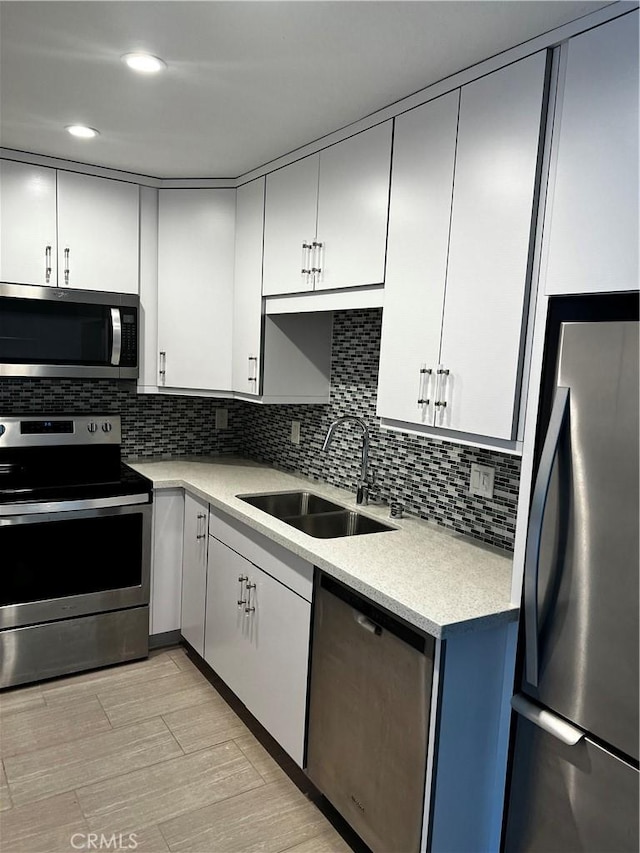 6330 Genesee Ave Unit 103, San Diego, CA 92122 - kitchen with stainless steel appliances, a sink, light countertops, decorative backsplash, and white cabinetry