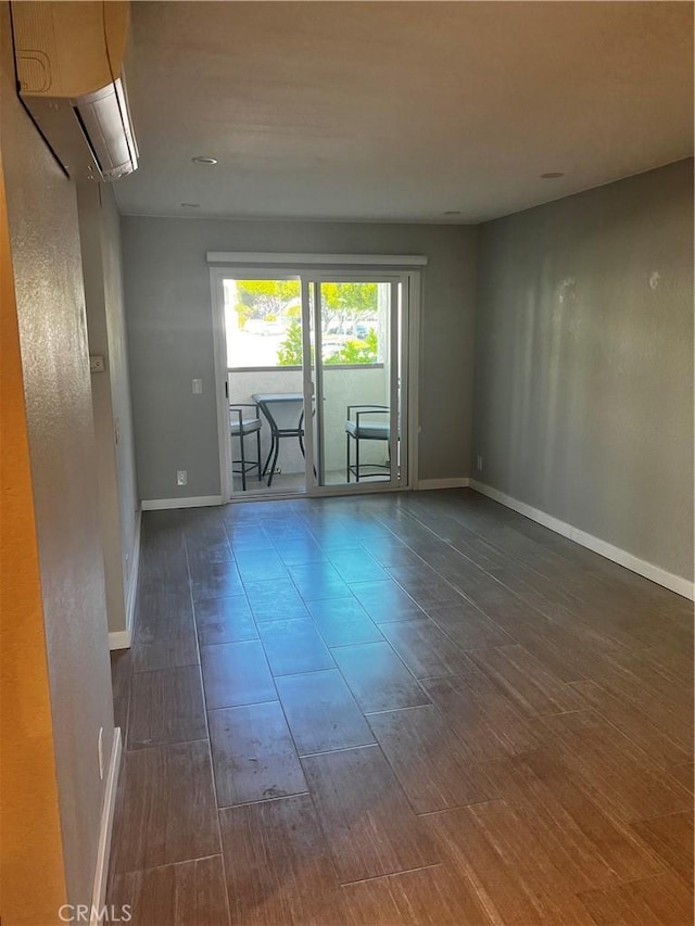 6330 Genesee Ave Unit 103, San Diego, CA 92122 - unfurnished room featuring an AC wall unit, dark wood-type flooring, and baseboards