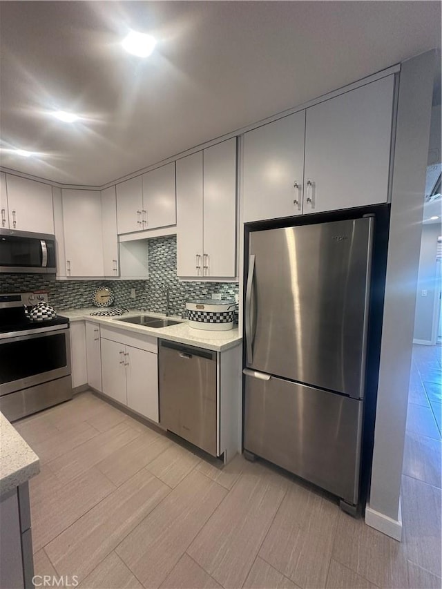 6330 Genesee Ave Unit 103, San Diego, CA 92122 - kitchen with appliances with stainless steel finishes, backsplash, and light stone countertops