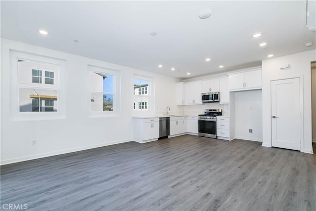 667 Limoncello Ln, Covina, CA 91723 - kitchen with stainless steel appliances, wood finished floors, white cabinetry, recessed lighting, and baseboards