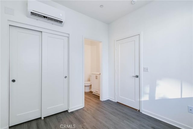 667 Limoncello Ln, Covina, CA 91723 - unfurnished bedroom featuring an AC wall unit, wood finished floors, a closet, baseboards, and ensuite bath