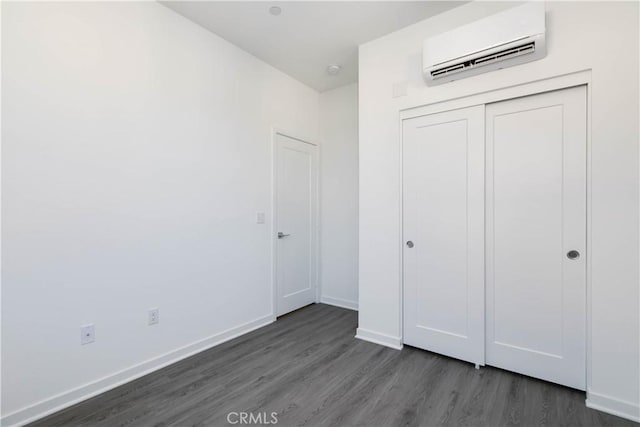 667 Limoncello Ln, Covina, CA 91723 - unfurnished bedroom with an AC wall unit, dark wood-style flooring, baseboards, and a closet