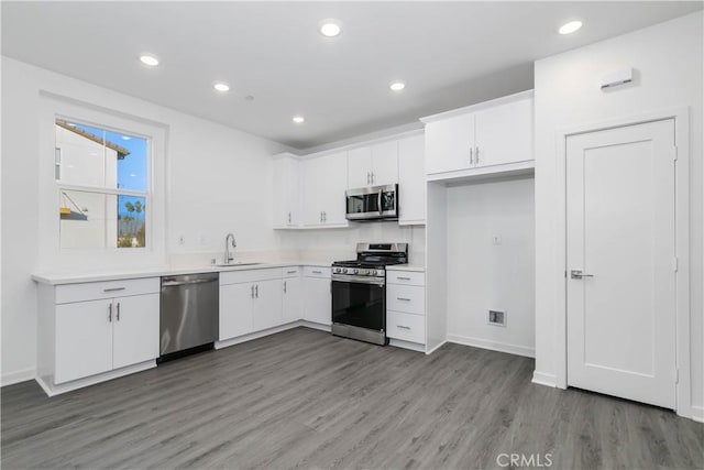 667 Limoncello Ln, Covina, CA 91723 - kitchen with appliances with stainless steel finishes, a sink, white cabinets, light wood finished floors, and light countertops
