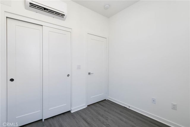 667 Limoncello Ln, Covina, CA 91723 - unfurnished bedroom featuring a wall mounted air conditioner, dark wood-style flooring, baseboards, and a closet