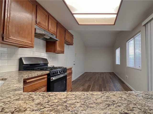 13941 Parkwood Dr, Fontana, CA 92337 - kitchen with black gas range oven, under cabinet range hood, backsplash, brown cabinets, and lofted ceiling
