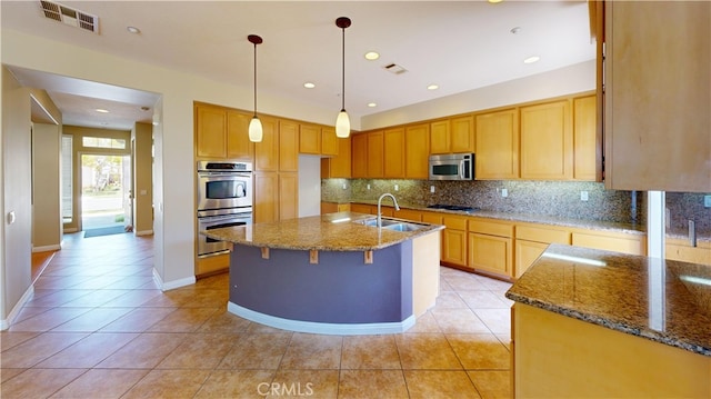 4312 Waterside Ln, Oxnard, CA 93035 - kitchen featuring stainless steel appliances, a sink, dark stone countertops, light tile patterned floors, and recessed lighting