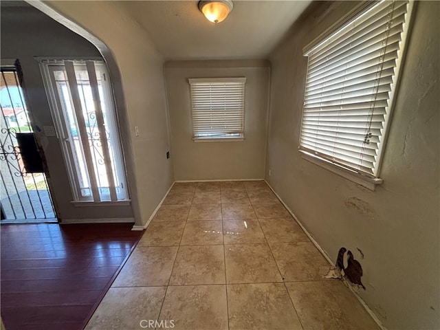 1434 W 92nd St, Los Angeles, CA 90047 - doorway to outside featuring tile patterned floors, arched walkways, and baseboards