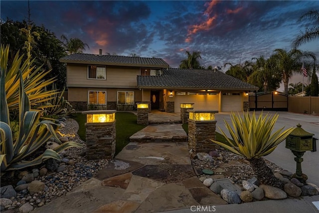 17927 Sun Hill Dr, Yorba Linda, CA 92886 - view of front of property featuring a fire pit, driveway, a garage, stone siding, and stucco siding