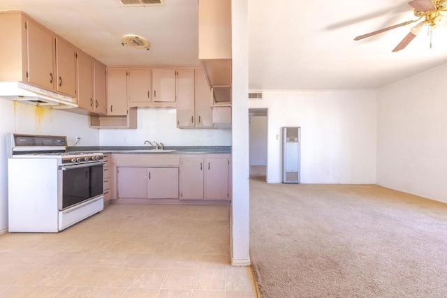 630 N Palm Dr, Brawley, CA 92227 - kitchen featuring white range with gas stovetop, under cabinet range hood, ceiling fan, and light carpet
