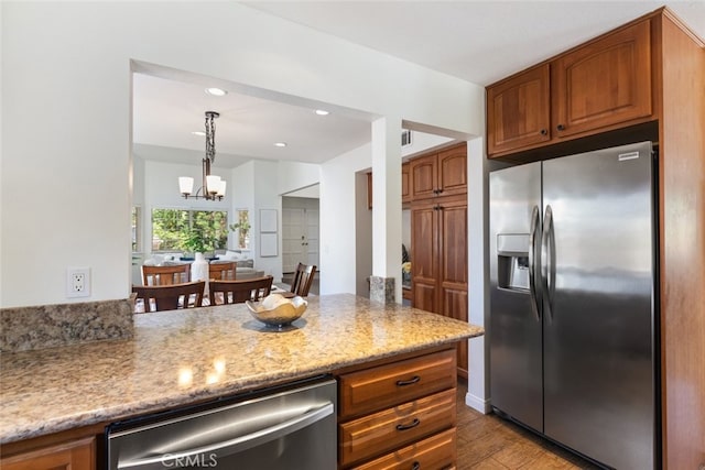 1188 Old Hickory Rd, Corona, CA 92882 - kitchen with stainless steel appliances, brown cabinets, a chandelier, wood finished floors, and recessed lighting